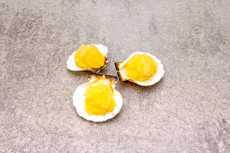 Capelin roe in seashells. Lightly salted caviar snack on a stone background.の写真素材