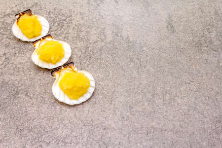 Capelin roe in seashells. Lightly salted caviar snack on a stone background.