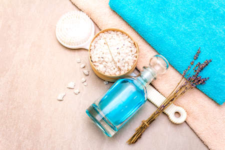 Spa concept, natural ingredients. Bath towels, sea salt with lavender, shower gel, brush. On a stone background, top view.の写真素材