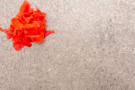 Pickled sushi ginger slices isolated on stone background, top view