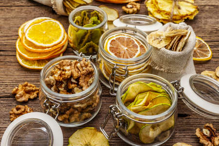 Zero waste food shopping concept. Assortment of dried fruits, walnuts. Sustainable lifestyle, old wooden boards background, close upの写真素材