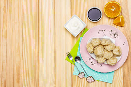 Fish dumplings. The concept of healthy food for children. Sour cream, soy sauce, cutlery. Wooden background, copy space, top viewの写真素材