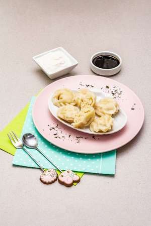 Fish dumplings. The concept of healthy food for children. Kids cutlery, sour cream, soy sauce. Stone concrete background, copy spaceの写真素材