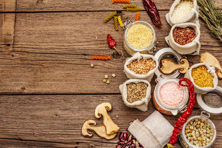 Zero waste food shopping concept. Cereals, pasta, legumes, dried mushrooms, spices. Sustainable lifestyle, old wooden boards background, copy space, top viewの写真素材