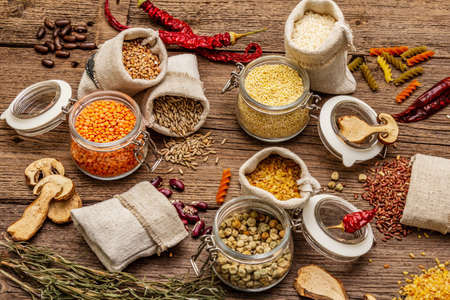 Zero waste food shopping concept. Cereals, pasta, legumes, dried mushrooms, spices. Sustainable lifestyle, old wooden boards background, close upの写真素材