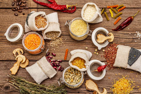 Zero waste food shopping concept. Cereals, pasta, legumes, dried mushrooms, spices. Sustainable lifestyle, old wooden boards background, top viewの写真素材