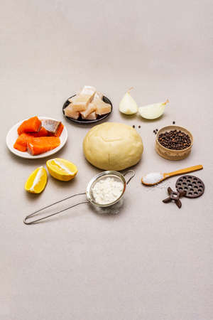 Fish dumplings. Ingredients for home cooking. Fresh dough, fish, spices, cooking equipment. Stone concrete backgroundの写真素材