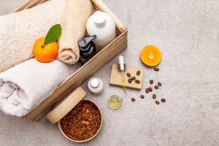Coffee and tangerine spa concept. Towels, oil, scrub, soap, lotion. Natural ingredient, wooden box. Stone concrete background, copy space, top viewの写真素材