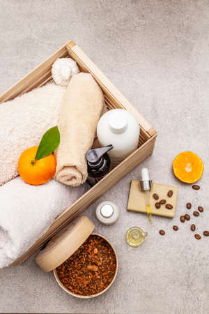 Coffee and tangerine spa concept. Towels, oil, scrub, soap, lotion. Natural ingredient, wooden box. Stone concrete background, copy space, top view, close upの写真素材