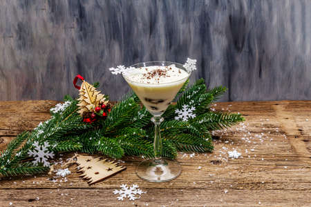 Traditional prune dessert with walnuts and whipped sour cream with sugar. New Year's sweet treat concept. Wooden boards background, copy spaceの写真素材