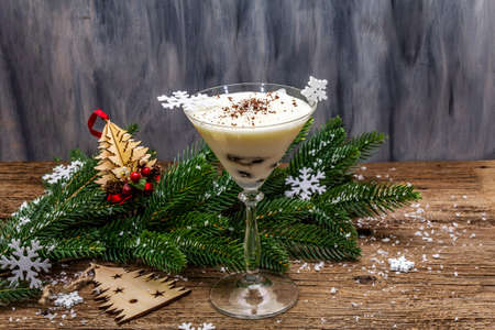 Traditional prune dessert with walnuts and whipped sour cream with sugar. New Year's sweet treat concept. Wooden boards background, copy spaceの写真素材