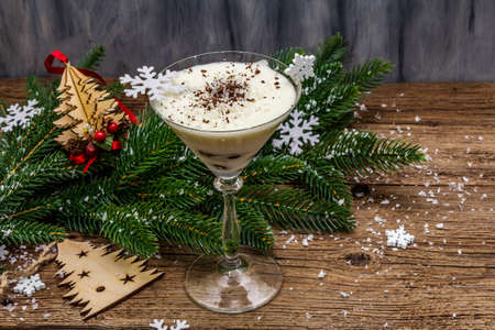 Traditional prune dessert with walnuts and whipped sour cream with sugar. New Year's sweet treat concept. Wooden boards background, copy spaceの写真素材