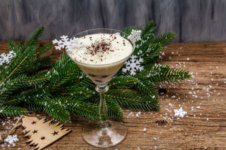 Traditional prune dessert with walnuts and whipped sour cream with sugar. New Year's sweet treat concept. Wooden boards background, copy spaceの写真素材