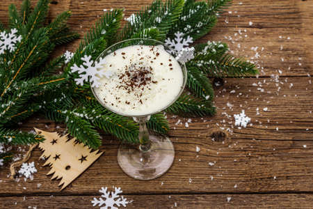 Traditional prune dessert with walnuts and whipped sour cream with sugar. New Year's sweet treat concept. Wooden boards background, top viewの写真素材
