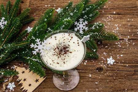 Traditional prune dessert with walnuts and whipped sour cream with sugar. New Year's sweet treat concept. Wooden boards background, top viewの写真素材