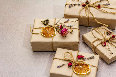 Zero waste gift concept. Valentine Day or Birthday eco friendly packaging. Festive boxes in craft paper with different organic decorations. Stone concrete background, close upの写真素材
