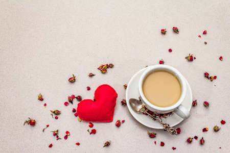 Good morning. Cup of coffee, rose buds and petals, red felt heart. Romantic breakfast, Valentine's Day. Stone concrete background, copy space, top viewの写真素材