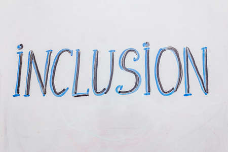Hand drawn word "inclusion" on marker board. Blue and black color, white backgroundの写真素材
