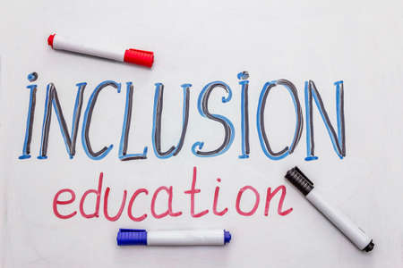 Hand drawn word "inclusion education" on marker board. Blue and black color, white backgroundの写真素材