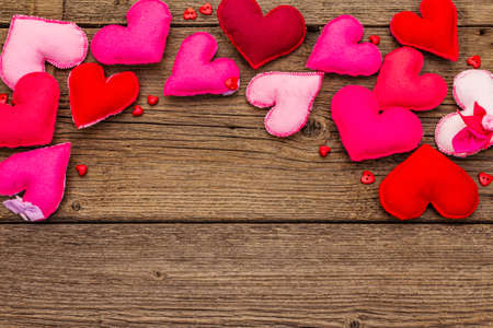 Valentines Day or Wedding background. Romantic and love emotion. Multicolored felt hearts on vintage wooden boards background, copy space, top viewの写真素材