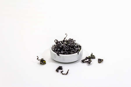 Dry wakame seaweed isolated on white background. Plate of dried kombu algae, traditional Japanese ingredient for cooking Dashi soup, copy spaceの写真素材