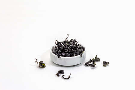 Dry wakame seaweed isolated on white background. Plate of dried kombu algae, traditional Japanese ingredient for cooking Dashi soup, copy spaceの写真素材