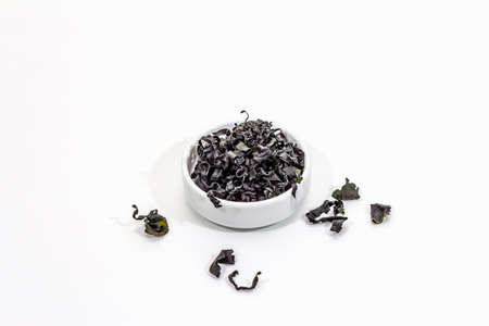 Dry wakame seaweed isolated on white background. Plate of dried kombu algae, traditional Japanese ingredient for cooking Dashi soup, copy spaceの写真素材