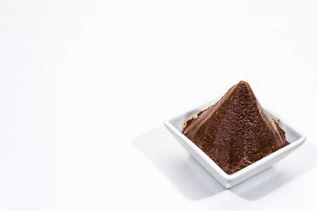 Dark brown miso paste isolated on white background. Traditional Japanese seasoning, indispensable ingredient for cooking soup stock, copy space, close upの写真素材