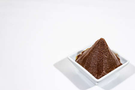 Dark brown miso paste isolated on white background. Traditional Japanese seasoning, indispensable ingredient for cooking soup stock, copy space, close upの写真素材