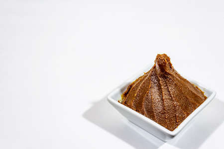 Light brown miso paste isolated on white background. Traditional Japanese seasoning, indispensable ingredient for cooking soup stock, copy space, close upの写真素材