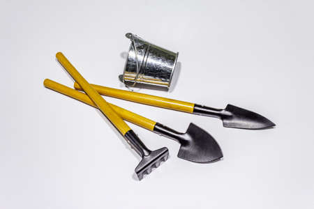 Garden tools isolated on white background. Plant care concept. Shovels, bucket and rakeの写真素材