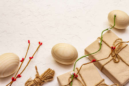 Zero waste Easter concept. Wooden eggs, gifts in craft paper. Not plastic, eco trend. White putty...