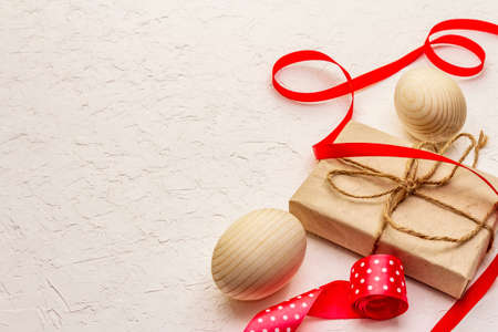 Zero waste Easter concept. Wooden eggs, gifts in craft paper. Not plastic, eco trend. White putty background, copy spaceの写真素材