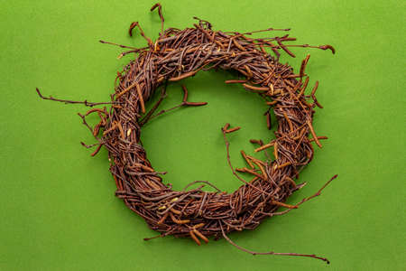 Wicker wreath of birch branches. Easter zero waste, DIY concept. Design element and decor. Green background, close up, top viewの写真素材