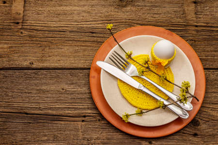Easter table setting on old wooden background. Spring holiday card template. Cutlery, crochet...