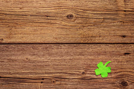 Felt clover leaf on old wooden background. Good luck symbol, St.Patrick's Day concept, top view