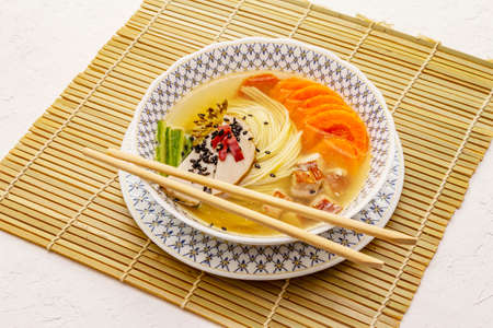 Korean noodle soup with smoked chicken and vegetables. Spicy dish for healthy meal. White putty...