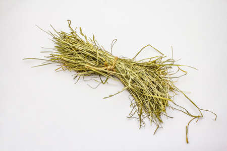 Bunch of hay isolated on white background. Dry herbs, food for domestic animals