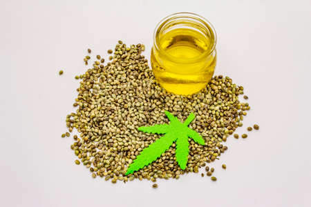 Ripe hemp seeds, oil and felt leaf isolated on white background. Trend food, medicine and beauty ingredient, healthy lifestyle conceptの写真素材