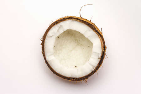 Ripe coconut cut on two half isolated on white background. Fresh fruit, ingredient for cooking food or beauty self careの写真素材