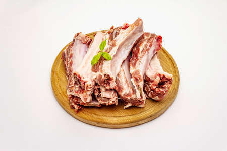 Raw pork ribs isolated on white background. Round wooden cutting boardの写真素材