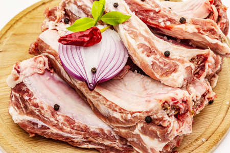Raw pork ribs isolated on white background. Round wooden cutting boardの写真素材