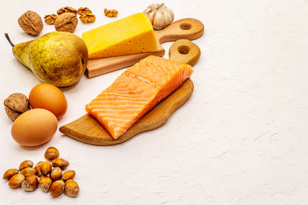 Trendy ketogenic diet products set. Vegetarian keto low carbs nutrition. Fish, cheese, fruits and vegetables. White putty background, copy spaceの写真素材