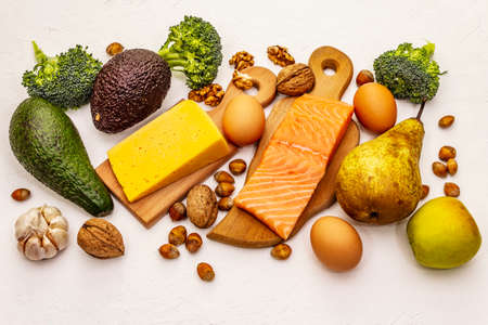 Trendy ketogenic diet products set. Vegetarian keto low carbs nutrition. Fish, cheese, fruits and vegetables. White putty background, top view, close upの写真素材