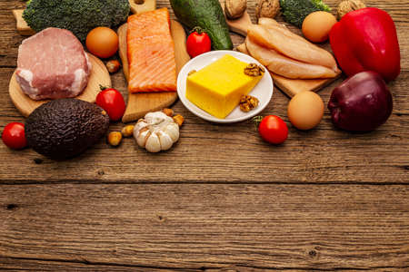 Trendy ketogenic diet products set. Paleo, pegan low carbs nutrition. Meat, fish, cheese, fruits and vegetables. Wooden boards backgroundの写真素材