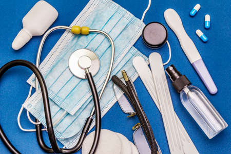 Set of diverse medical items. Means for the prevention, personal hygiene and treatment of the symptoms of coronavirus. COVID-19 pandemic, 2019-nCoV worldwide concept. Blue background, top viewの写真素材