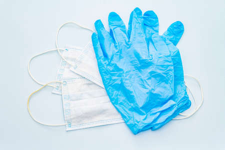 Mask and gloves isolated on blue background. Medical products for personal hygiene and the prevention of viral diseases. Coronavirus, COVID-19 pandemic, 2019-nCoV worldwide conceptの写真素材