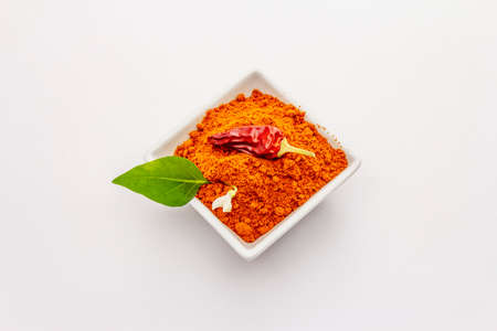 Hungarian hot paprika powder isolated on white background. Traditional seasoning in ceramic plateの写真素材