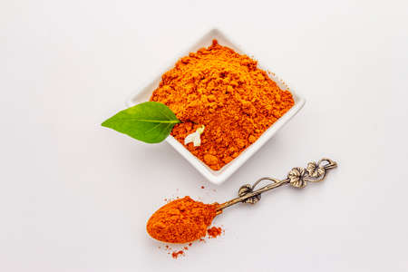 Hungarian hot paprika powder isolated on white background. Traditional seasoning in ceramic plateの写真素材