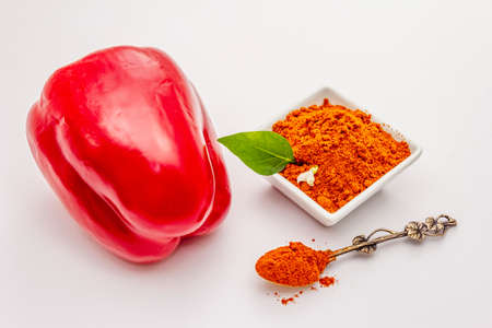 Hungarian hot paprika powder isolated on white background. Traditional seasoning in ceramic plateの写真素材